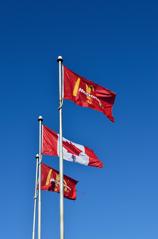 Two McDonald's flags with one Canadian flag in the middle
