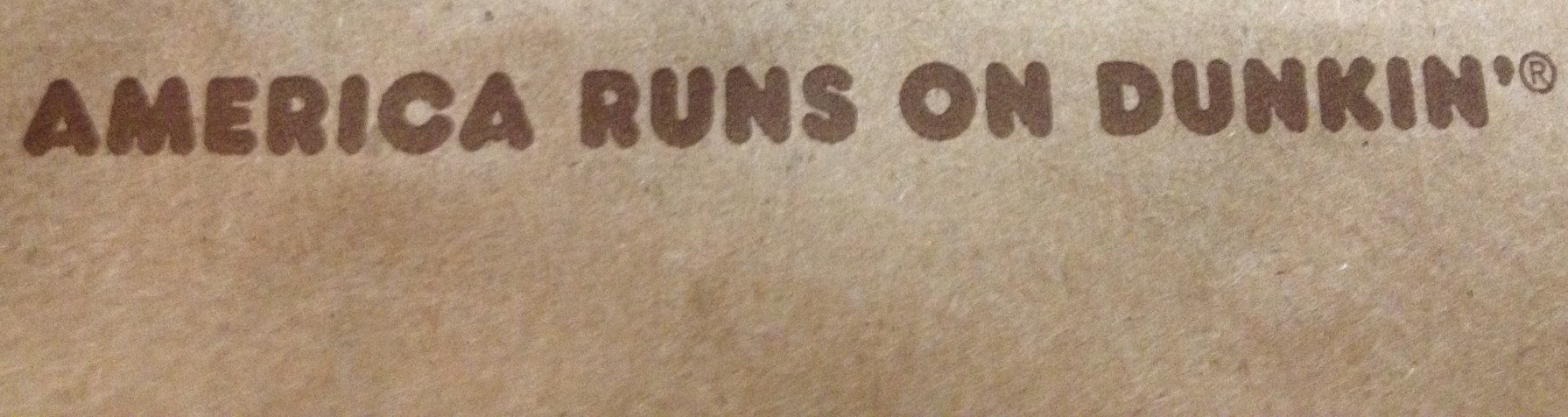 Part of a paper bag that says "America Runs on Dunkin'"