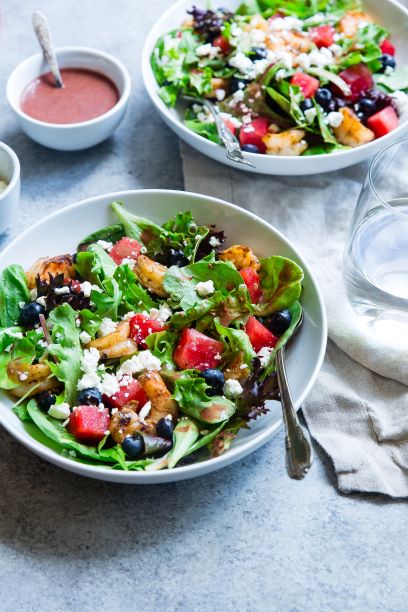 Image of 2 salads with bowl of dressing