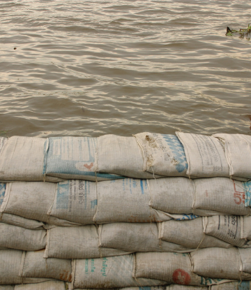 Supply Chain Scene, image of sand bags holding back water 