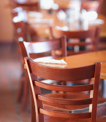 SCS image of an empty chair at an empty table in a restaurant 
