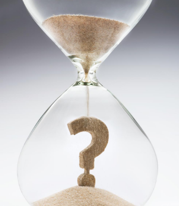 Image of an hour glass with sand in the shape of a question mark 