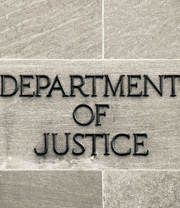 Closeup image of the sign on the Department of Justice Building 