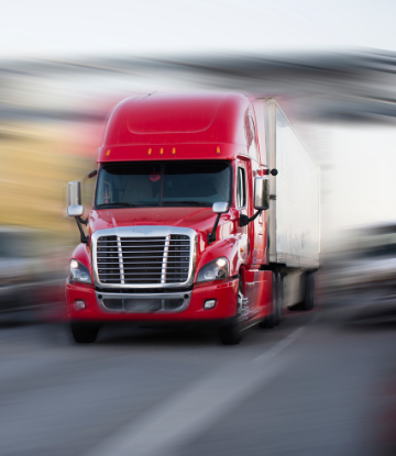 Bluured image of an 18-wheeler truck moving down the highway 