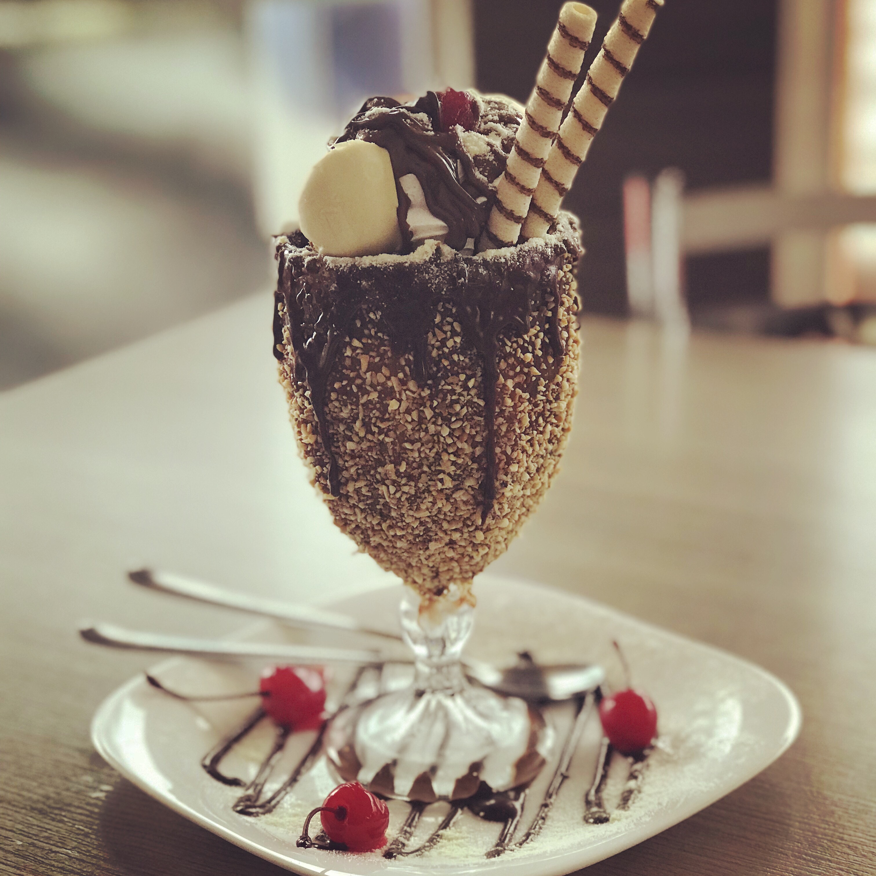 Vanilla ice cream sundae with chocolate sauce, two wafers and cherries