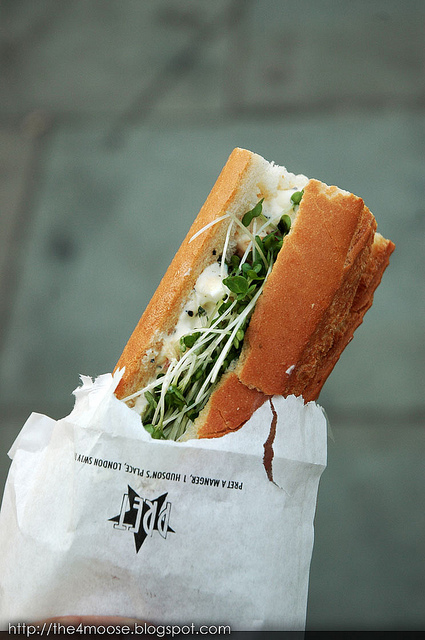Sandwich sticking out of white paper bag labeled "Pret a Manager"