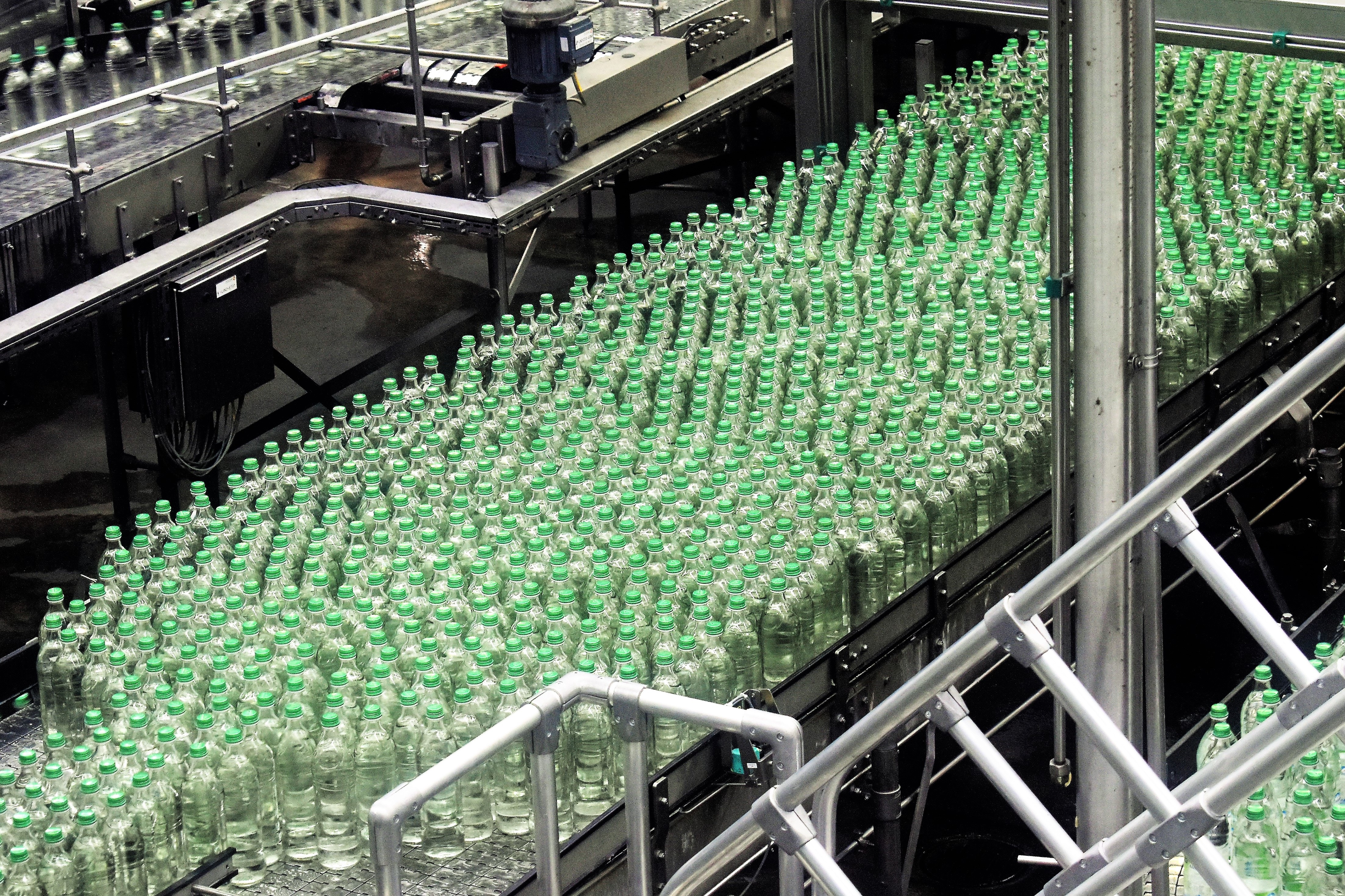 Green glass bottles on a manufacturing line.