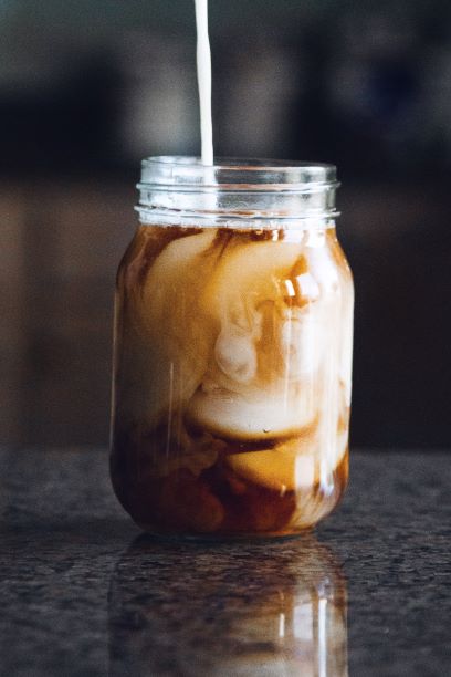 Coffee with cream and straw in mason jar