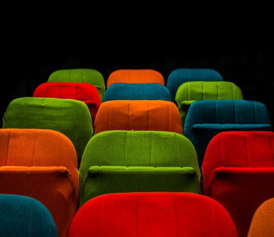 Multi-colored plush auditorium chairs.
