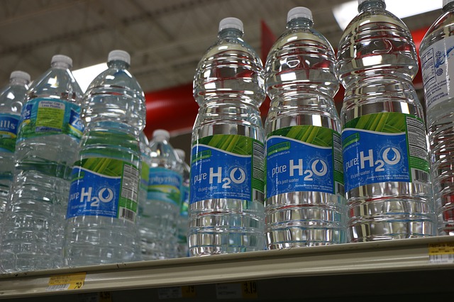Clear plastic water bottles on a shelf.