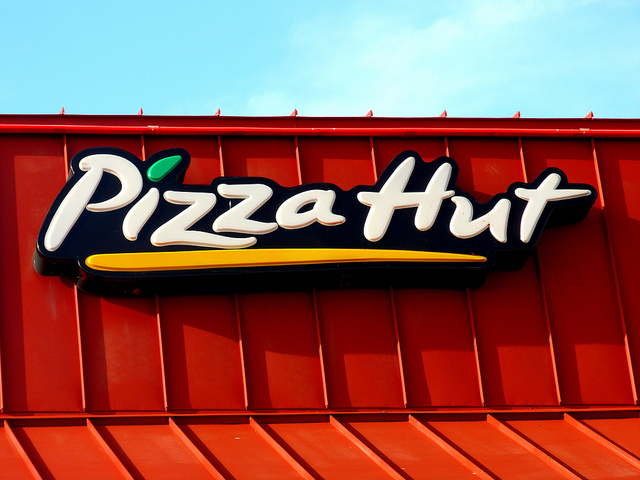 Pizza Hut sign across red, metal roof