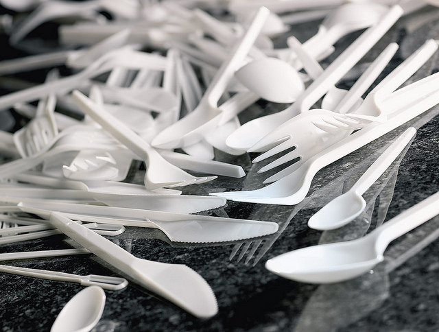 White plastic cutlery on black surface.