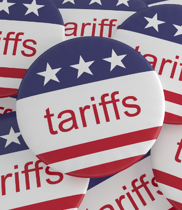 Image of a pile of red, white and blue buttons with the word "tariffs" on them 