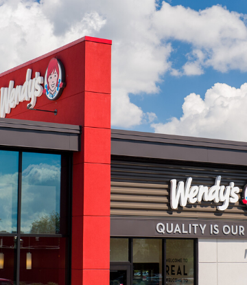 Image of a Wendy's storefront against a blue sky with white clouds 