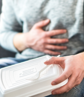 SCS, image of man holding a takeout container whle clutching his stomach 