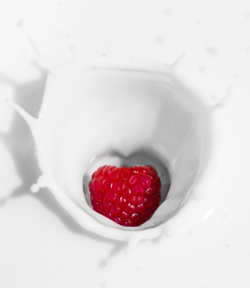 SCS, image of a heart shaped raspberry splashing in to fresh, white milk 