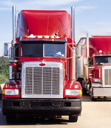 Image of 2 red 18-wheeler trucks 
