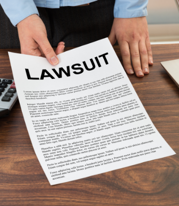 Image of a person holding a paper that say LAWSUIT in bold letters 