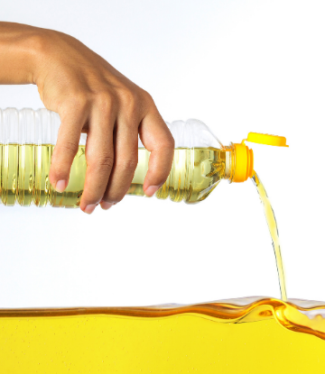 Hand pouring a bottle of vegetable oil 