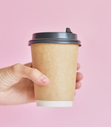 image of a hand holding a disposable coffee cup