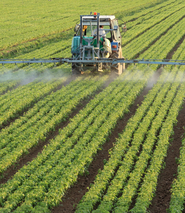 Tractor spraying fertilizer on crops 