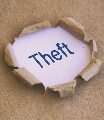 The word "theft" through a ripping paper box 