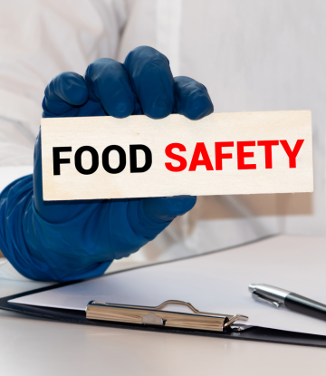 Food saefty sign held by a gloved hand 