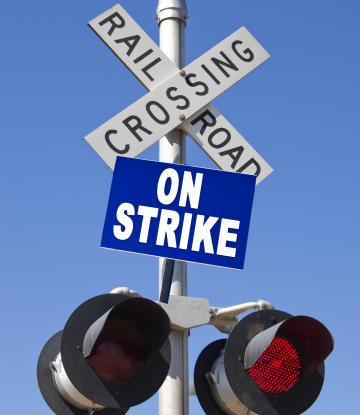 RR track sign next to a strike sign 